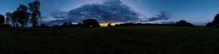 Закат на поле у города. Фотография.